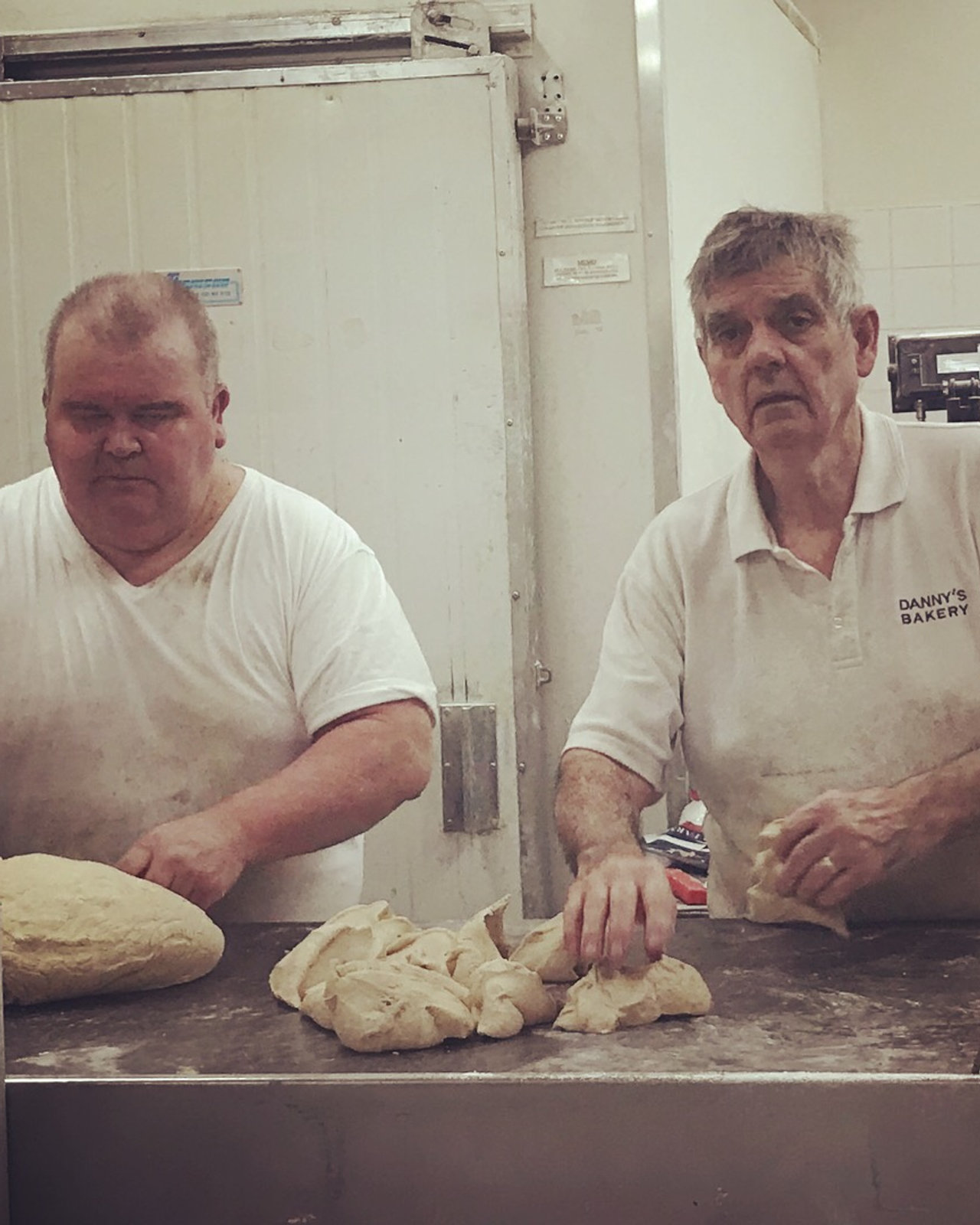 Jesse and Danny at the bench with trays of loaves