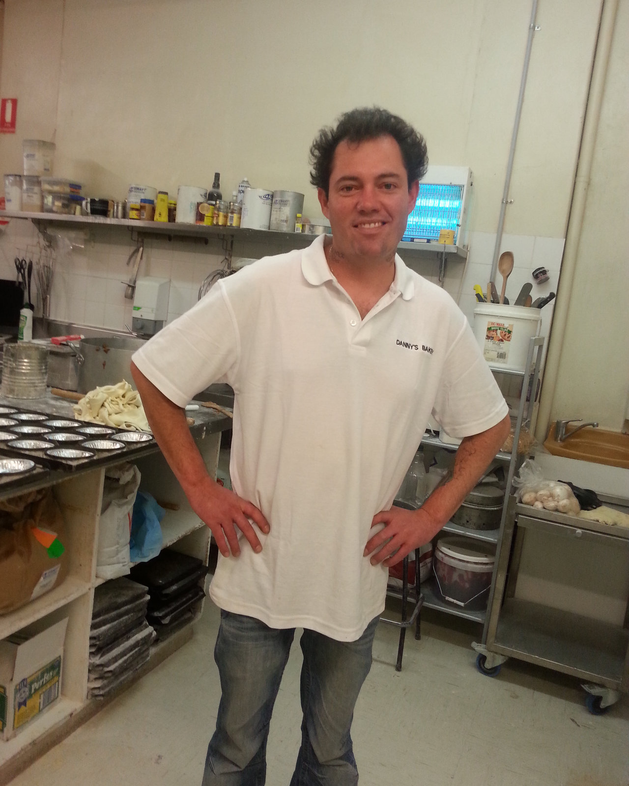 Russell in the bakery beside the morning trays