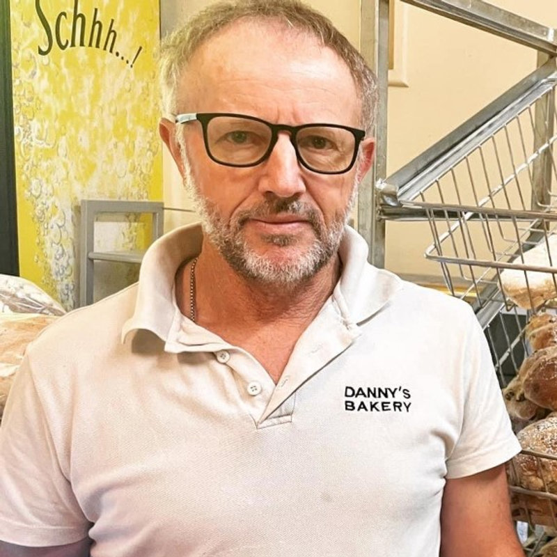 Wayne in his Danny's Bakery polo beside the racks